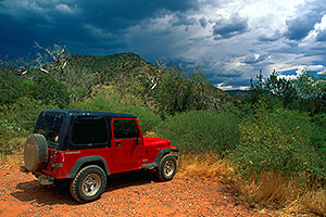 red Jeep Wrangler during monsoon season at Wet Beaver Creek by Sedona