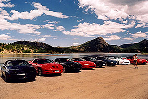 Ola photographing black, red and white Pontiac TransAm cars at Estes Lake