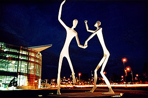 Denver Figures at night (by Performing Arts Center)