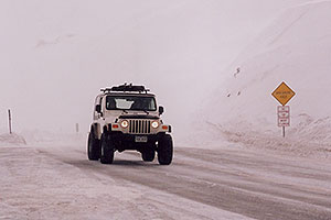 white Jeep Wranger in snowstorm at top of Loveland Pass