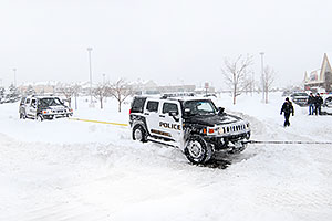 Snowplow rescuing two Police Hummers