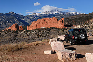 Land Rover Discovery overlooking Garden of the Gods with Pikes Peak in the clouds
