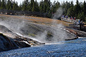 People returning from Excelsior Geyser Crater, and spring water flowing into Firehole River
