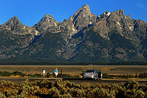 Photographer taking pictures in the morning of Grand Teton (center)