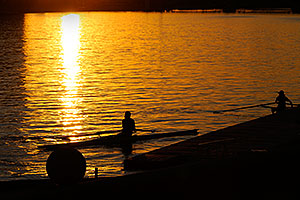 2 single scullers landing at the docks of North Bank Boat Ramp at Tempe Town Lake at sunset