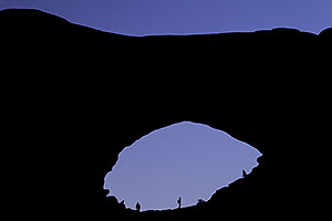 Silhouettes of people in North Window in Arches National Park