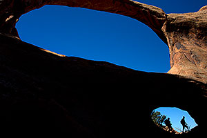 Hikers at Double O Arch in Arches National Park