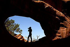 Photographer silhouette at Double O Arch in Arches National Park