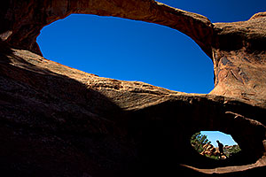 People at Double O Arch in Arches National Park